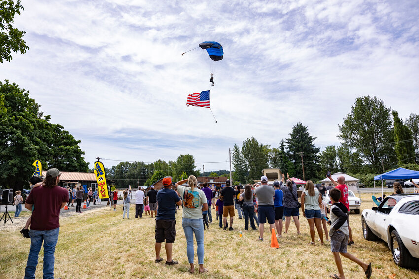 Skydiver Brett Martin lands while parachuting with an American flag during the sixth annual Adna Car Show on Friday, July 18.