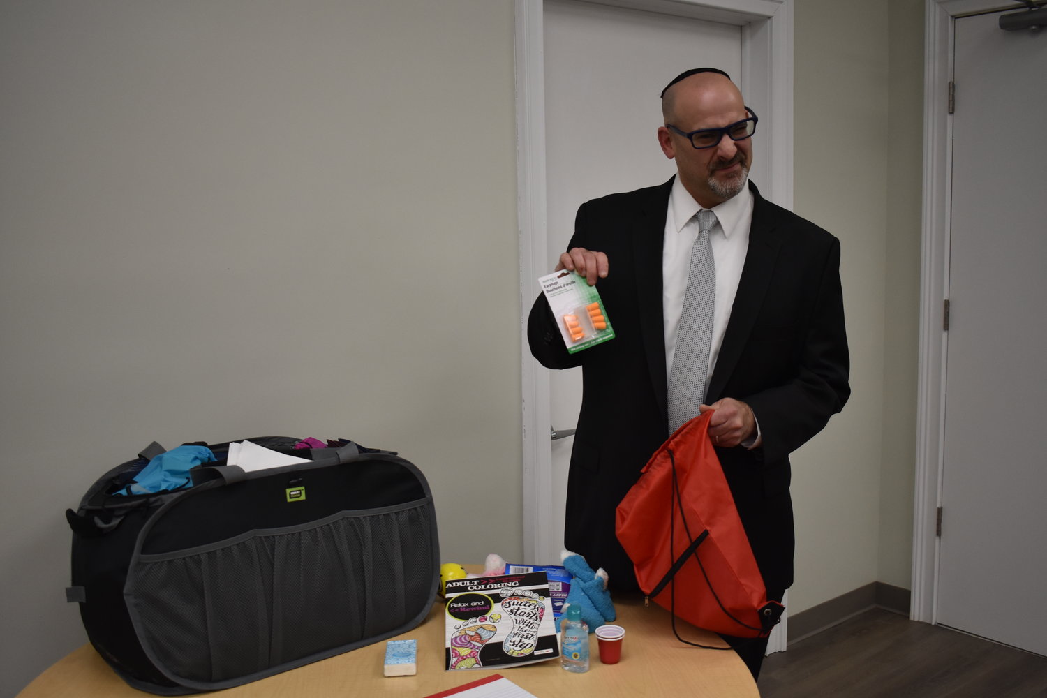 Dr. Steven Levey showed off the parental survival kits that he brought to hand out, they included everything from ear plugs and hand sanitizer to fuzzy socks and an adult coloring book.