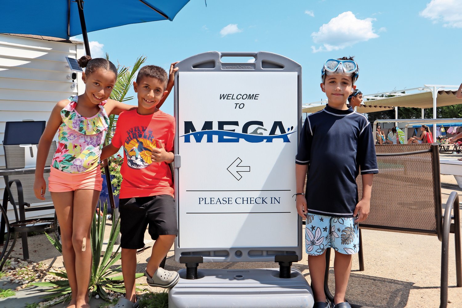 A few young visitors took time away from the pool for a picture next to MECA's entrance sign.