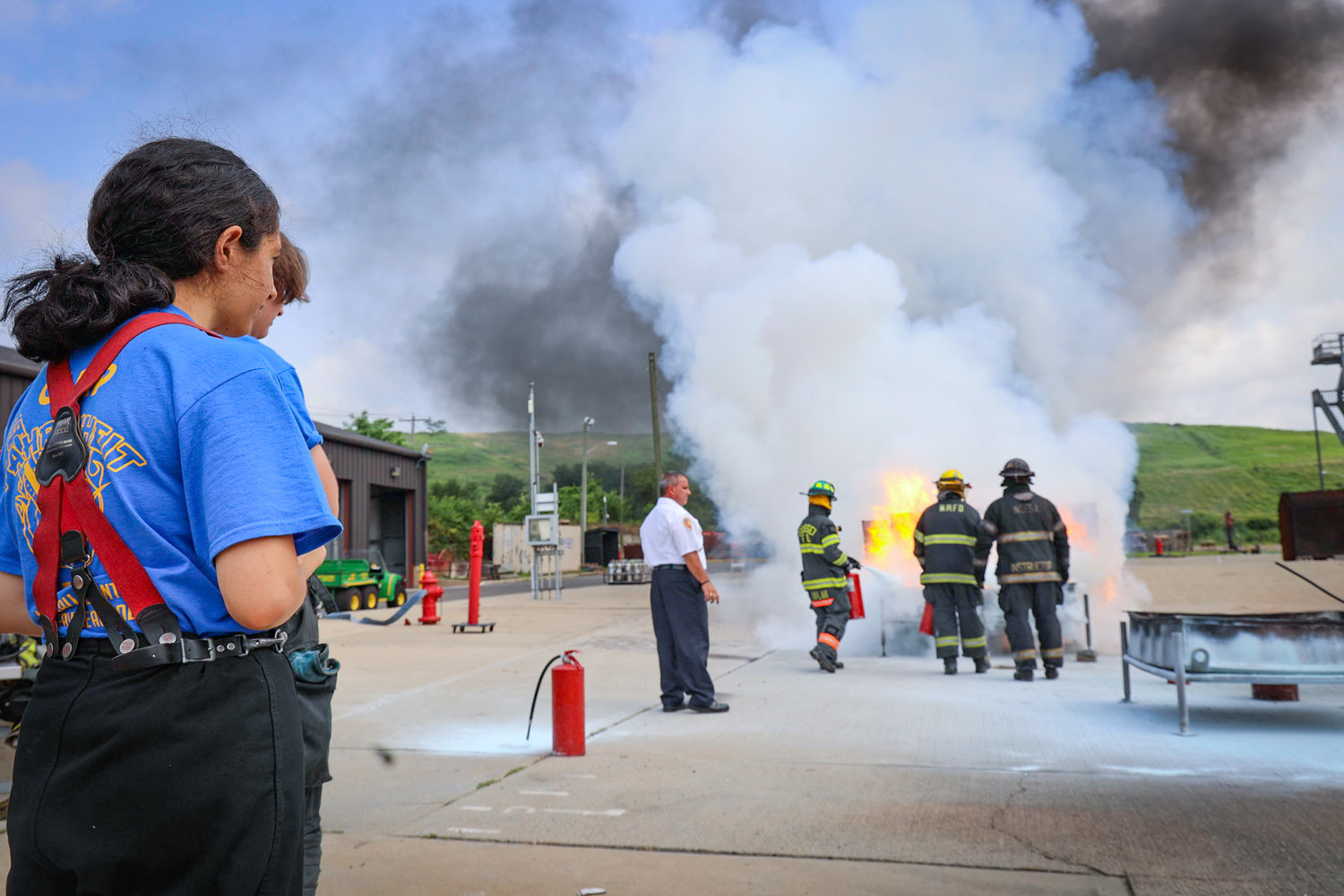 Khadeegah Memon, 14, of East Norwich is watching firefighters demonstrate extinguishing techniques at the Nassau County Fire Service Academy in Bethpage.
