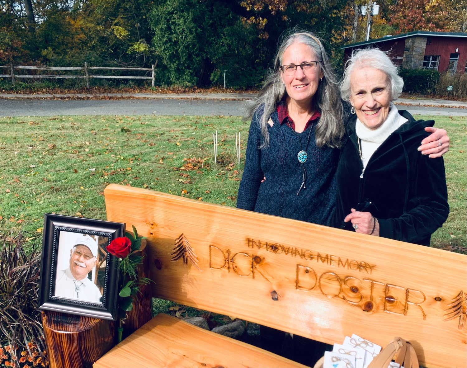 Richard Doster’s daughter Linda Notarnicola and his widow Joan stood behind the bench donated in Doster’s memory.
