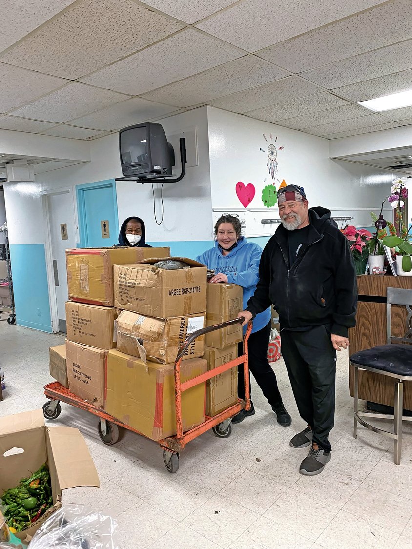 Luis Alvarez, a member of United Methodist Church of Sheepshead Bay, far left; Sasha Young, director of Gammy’s Pantry in Lawrence; and Syd Mandelbaum, founder of Rock and Wrap It Up, prepared for the Christmas Eve event at the Five Towns Community Center.
