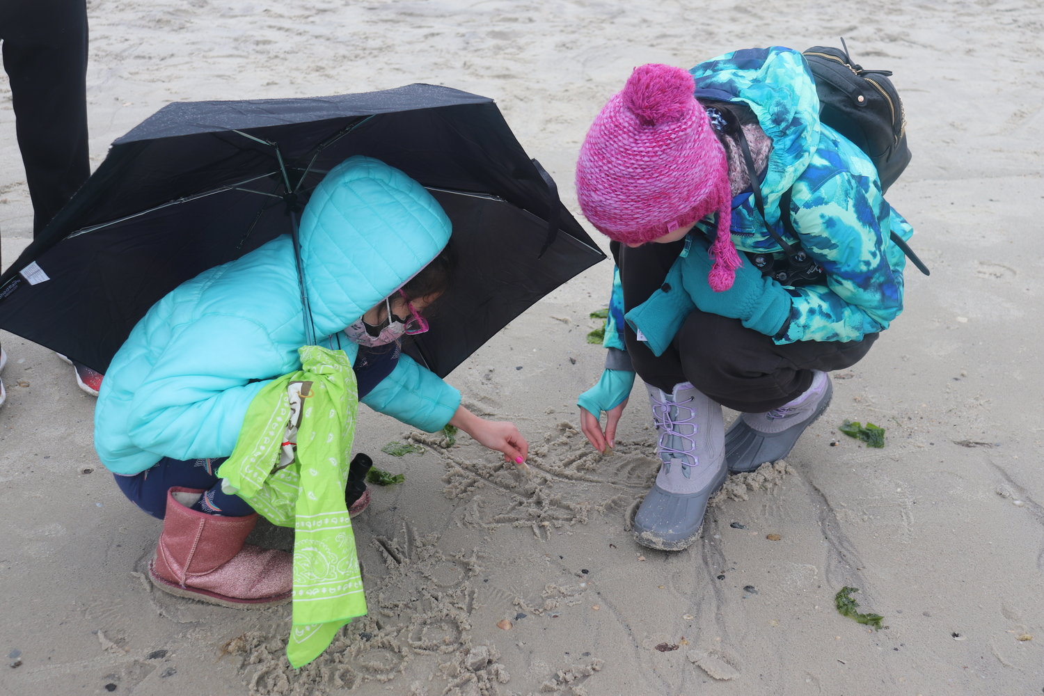 Maya Ostrow, 8, plays Tic-Tac-Toe in the sand with Sofia Ricci, 13.
