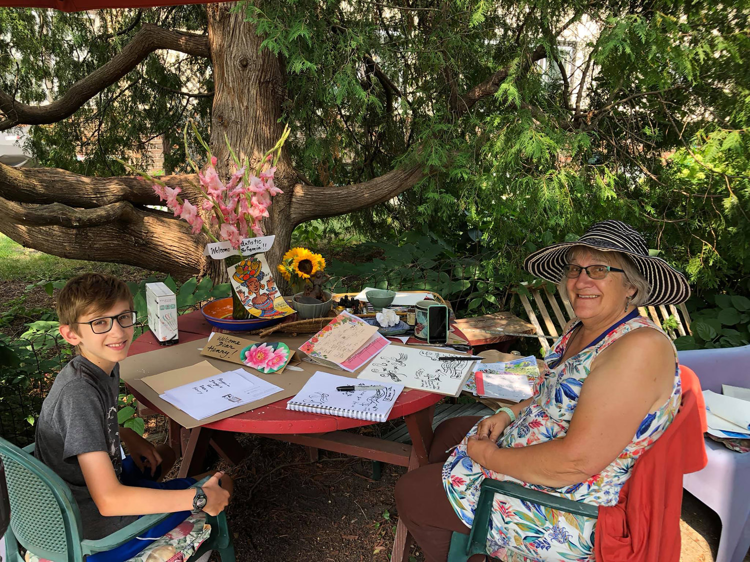 Artist Anita White (right) with art student Henry Holdsworth, in White’s garden. (Photo courtesy Hillary Oppmann)