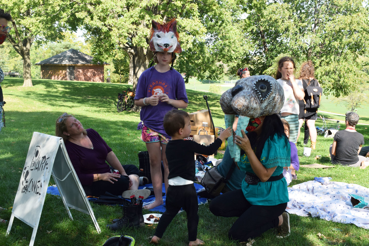 Community members of all ages try on masks at a Sunday BareBones gathering at Powderhorn Park. (Photo by Jill Boogren)