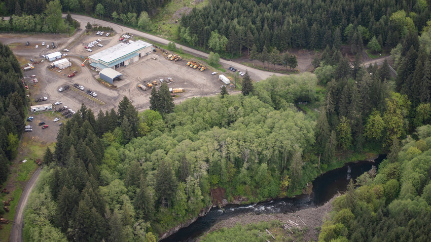 The Chehalis River runs beside logging trucks and the Weyerhaeuser office upstream of Pe Ell.