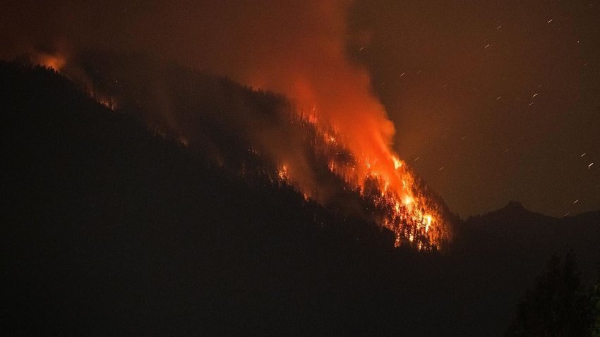 FILE PHOTO &mdash; Flames from the Goat Rocks Fire ignites trees as seen from Cannon Road in Packwood over Butler Creek in 2022.