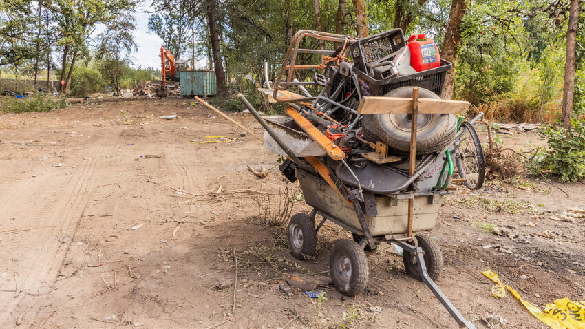A wagon packed with belongings sits at the end of Eckerson Road in Centralia as structures in a homeless community are demolished by crews from the Washington State Department of Transportation, which owns the land, on Wednesday, Sept. 6, 2023.
