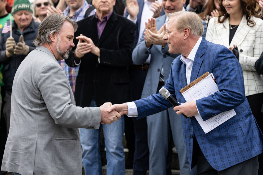 Radio host John Carlson shakes hands with Brian Heywood, Republican Party donor, during the &ldquo;Let&rsquo;s Go Washington&rdquo; initiatives rally at the Capitol in Olympia on Friday, Feb. 23, 2024.