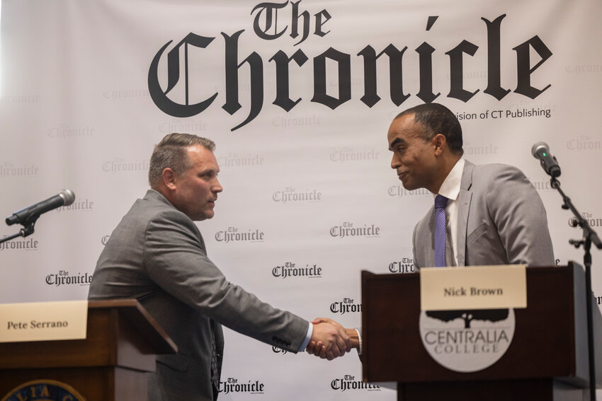 Pasco Mayor Pete Serrano, left, and former U.S. attorney for Western Washington and current Attorney General Nick Brown shake hands during a debate hosted by The Chronicle in the TransAlta Commons at Centralia College on Thursday, Sept. 26.