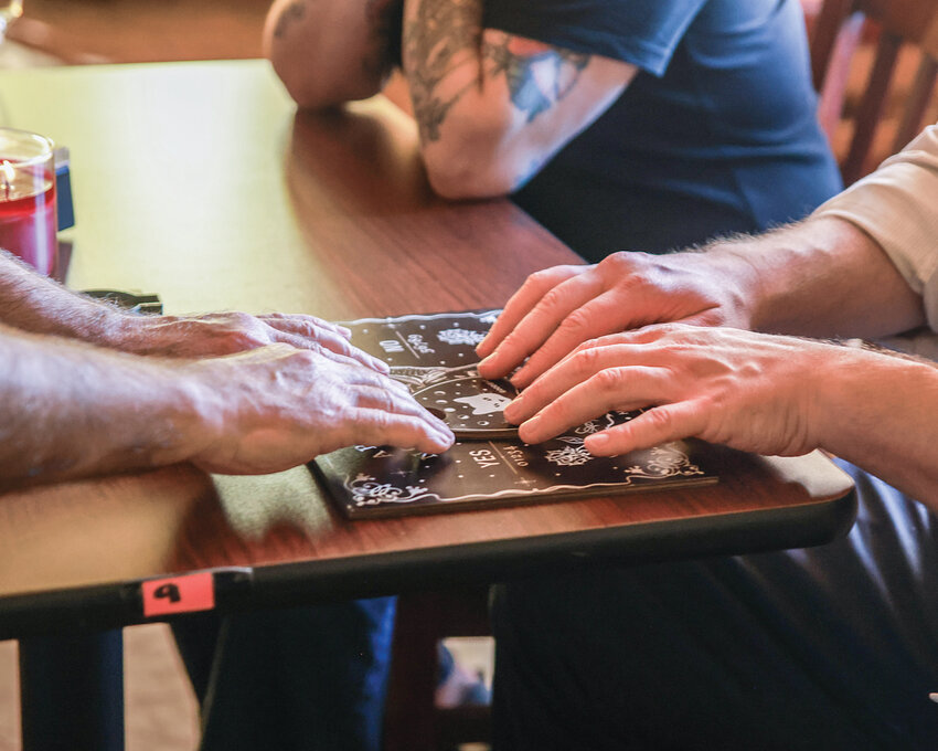 Paranormal investigator Jefferson Davis and Reflector sales specialist Billy Armstrong utilize a ouija board to contact spirits haunting the site of Julio&rsquo;s Coffee and Breakfast in Battle Ground on Oct. 6, where local lore says the property was once a brothel run by a woman named Mary, who wears a blue dress.