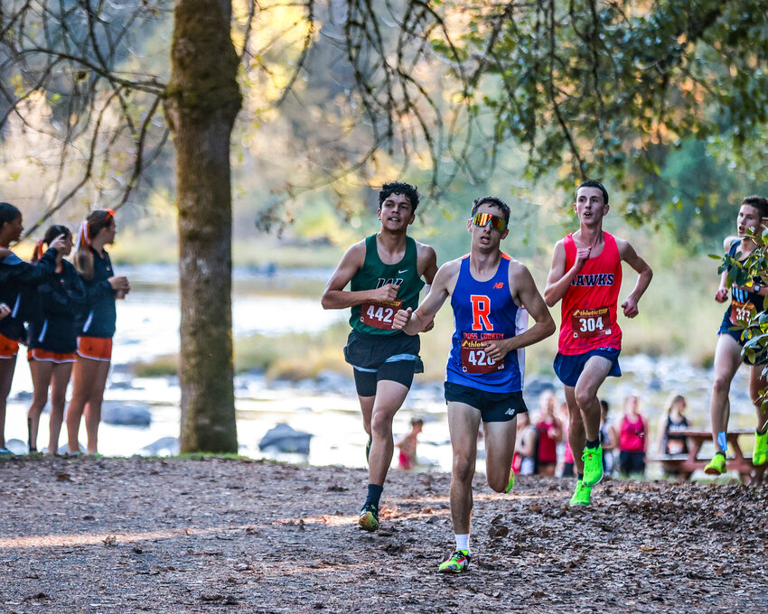 Woodland&rsquo;s Alejandro Alvarado, from left, Ridgefield&rsquo;s Evan Hollis and Hockinson&rsquo;s Tanner Hood run in a pack of three past East Fork Lewis River runners at Lewisville Park during the 2A Greater St. Helens League cross country championship on Tuesday, Oct. 22.