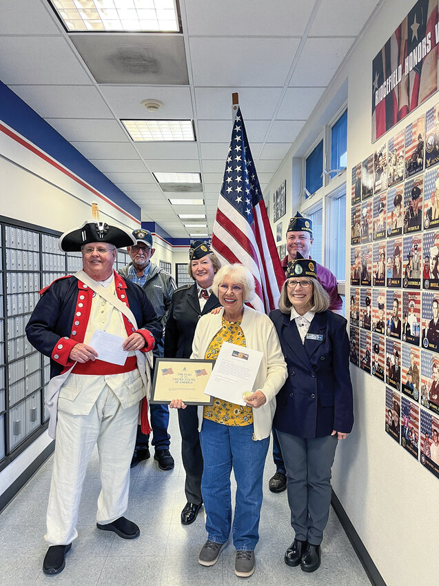 Tamara Gebelt, third from right, reunited with Ridgefield American Legion Post 44 member Judith Wyatt, lower right, to rekindle their high school friendship and to honor Gebelt&rsquo;s father, Army Capt. Henry F. C. Gebelt, at the Ridgefield post office.