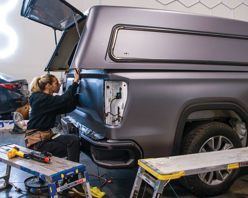 Excel Window Tinting and Auto Spa employee Joanna Vlaskenko installs a wrap on a vehicle at the shop in Brush Prairie on Wednesday, Oct. 30.