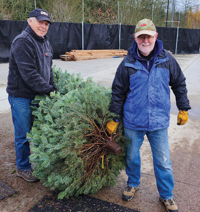 Ridgefield Lions Club members Steve Withers, left, and David Wright prepare to load a Christmas tree at the annual tree lot located at the Ridgefield Outdoor Recreation Center, 3101 S. Hillhurst Road.