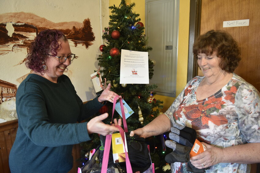 Janet Mashburn (left) and Jan Haig find a bundle of clothes donated by Ridgefield community members for their secret Santa program. Operation Secret Santa for Ridgefield Assisted Living has delivered gifts to the Ridgefield Living Center for nine years, never failing to meet the wishes of its residents.