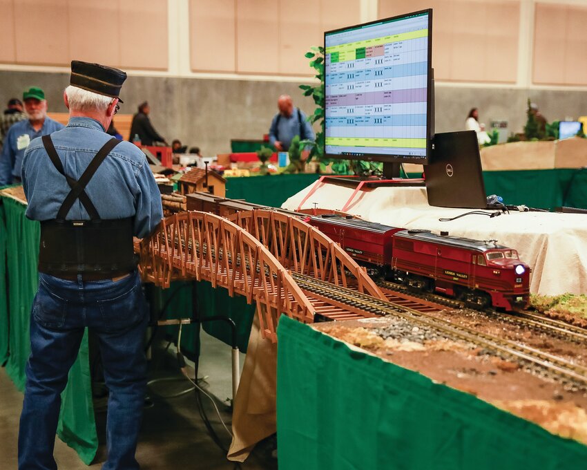 A G-scale model train makes a pass by a hobbyist at The Rose  City Garden Railroad at the Clark County Event Center in January 2023.