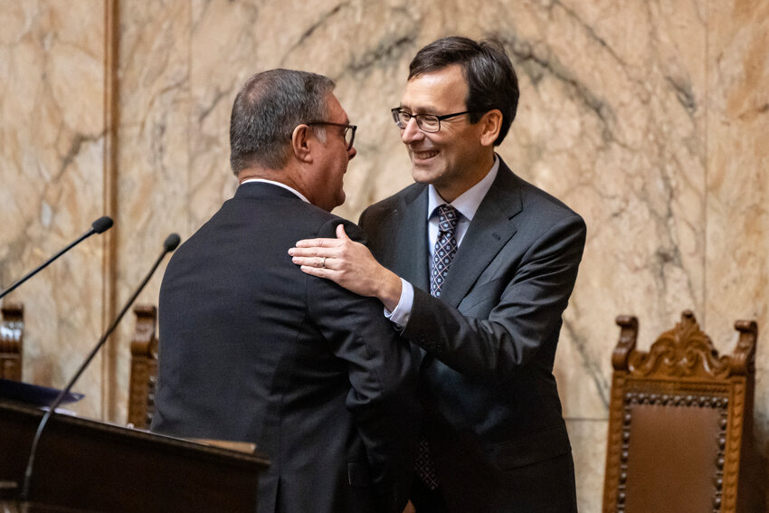 Gov. Bob Ferguson and Lt. Gov. Denny Heck embrace during a joint legislative session in House chambers at the Washington State Capitol in Olympia on Wednesday, Jan. 15.