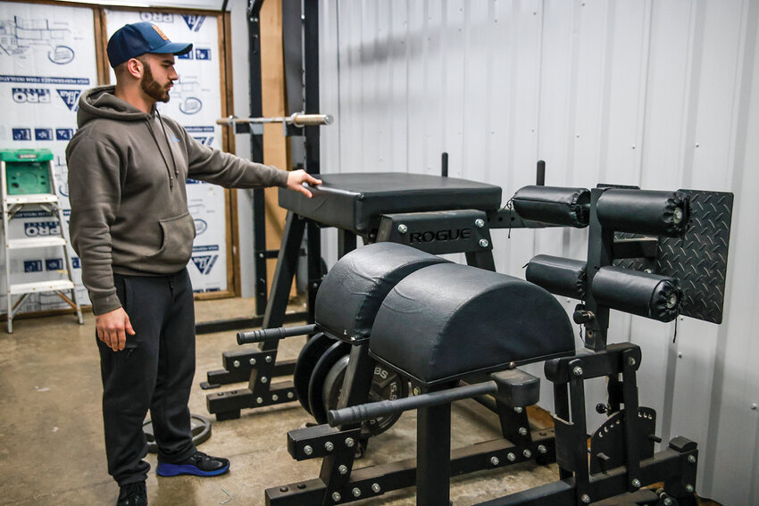Emerson Forrester, owner of Milestone CrossFit in Brush Prairie, highlights the glute and hamstring developer and reverse hyperextension machines at the shop on Wednesday, Jan. 15.