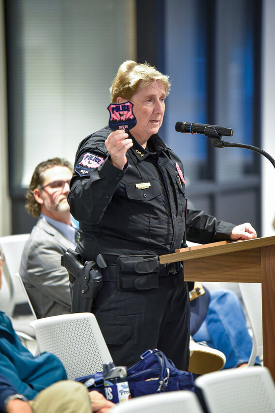 Ridgefield Police Chief Cathy Doriot holds up a Pink Patch during a Ridgefield City Council meeting. The Ridgefield Police Department raised $2,444.54 for breast cancer patients in 2024 through the Pink Patch program. The department's efforts support the Pink Lemonade Project, which provides vital resources for cancer patients and their families.