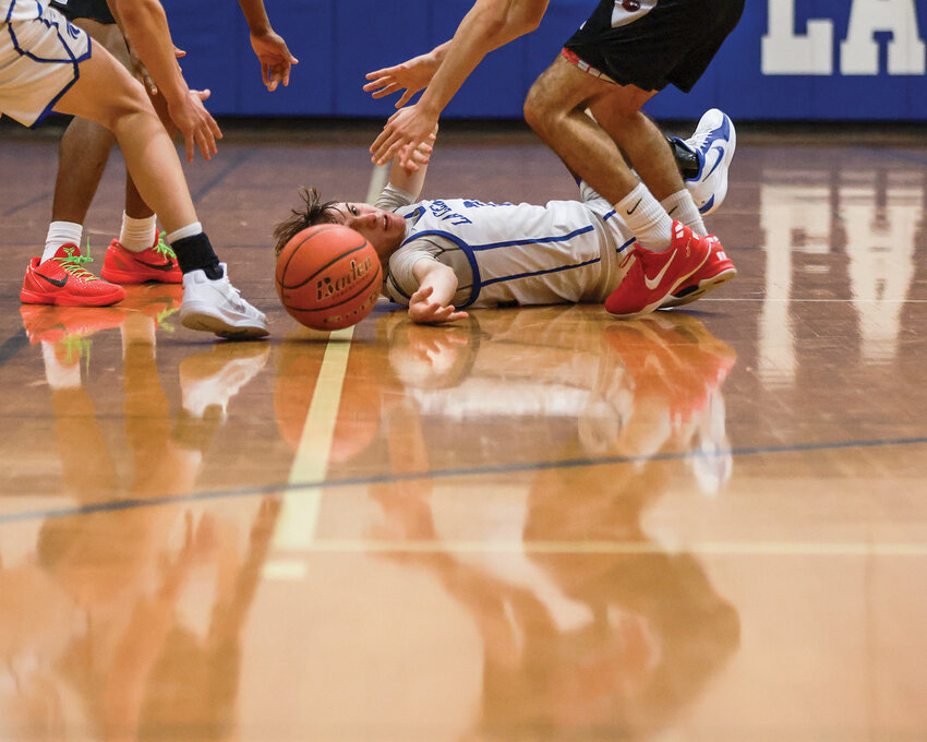 La Center senior guard Jayce Grotte reaches for a loose ball during the Wildcats&rsquo; 61-43 loss to the Fort Vancouver Trappers on Thursday, Jan. 16.