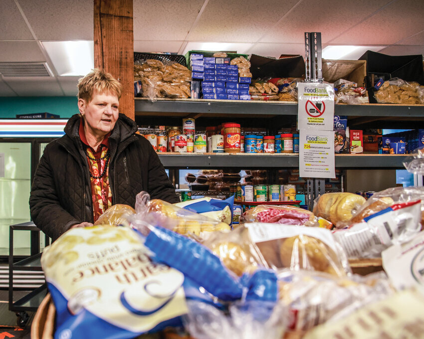 Food bank Executive Director Elizabeth Cerveny explains the amount of food donated to each family per month at the North County Community Food Bank in Battle Ground earlier this month.