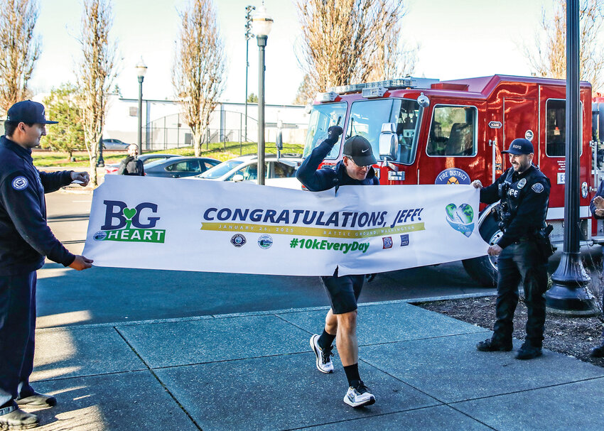 Jeff Grisso crosses a finish line at the Battle Ground Community Center. Over the last six and a half years, Grisso embarked on a walking goal to complete the distance equivalent to a trip around earth, which he completed on Saturday, Jan. 25, when he crossed mile 24,901.