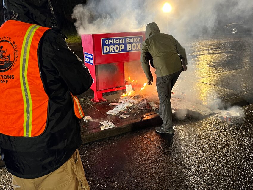 Officials douse the flames after an incendiary device was placed in a ballot box in Vancouver in November 2024. (Clark County Auditor&rsquo;s Office)