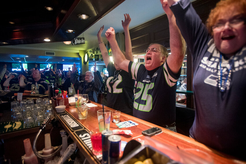 Bob Heymann, center-right, and his wife, Flossie, celebrate at O'Blarney's in Centralia after the Seattle Seahawks scored a touchdown late in the second quarter of Super Bowl XLIX in this Chronicle file photo.