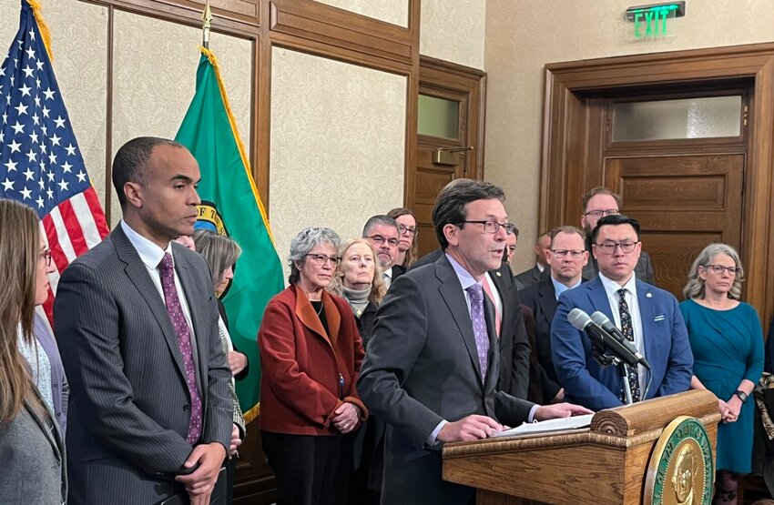Gov. Bob Ferguson, surrounded by other state elected leaders, speaks at a press conference in Olympia, on Feb. 13, 2025. (Photo by Bill Lucia/Washington State Standard)