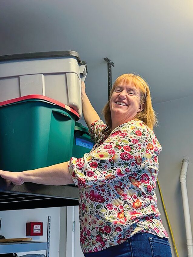 Kathy Boyd sorts and organizes storage bins in a client&rsquo;s garage, creating a functional and clutter-free space.