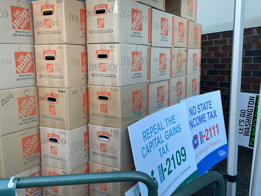 These boxes of petitions are for two of the six initiatives submitted to the Office of the Secretary of State in Washington in late 2023. Initiative 2111 was adopted by the Legislature and voters rejected Initiative 2109 in 2024. (Jerry Cornfield/Washington State Standard)