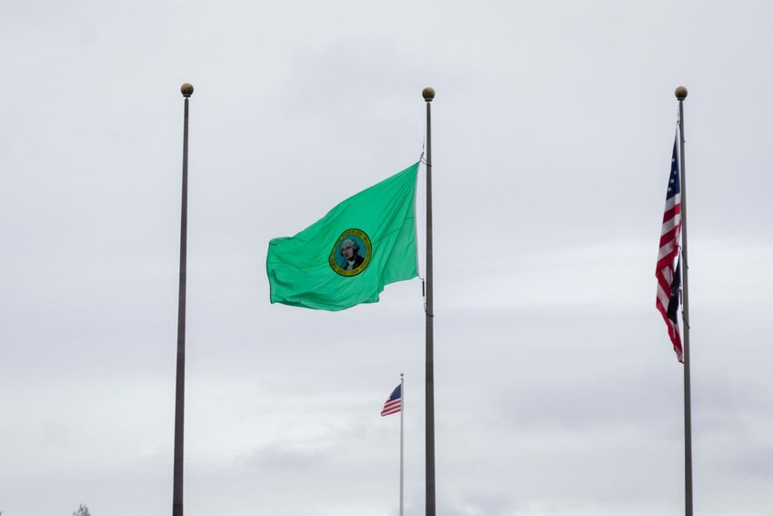 Washington state flag, flying in between the Legislative building and the Temple of Justice on Feb. 18, 2025. (Photo by Jacquelyn Jimenez Romero/Washington State Standard)