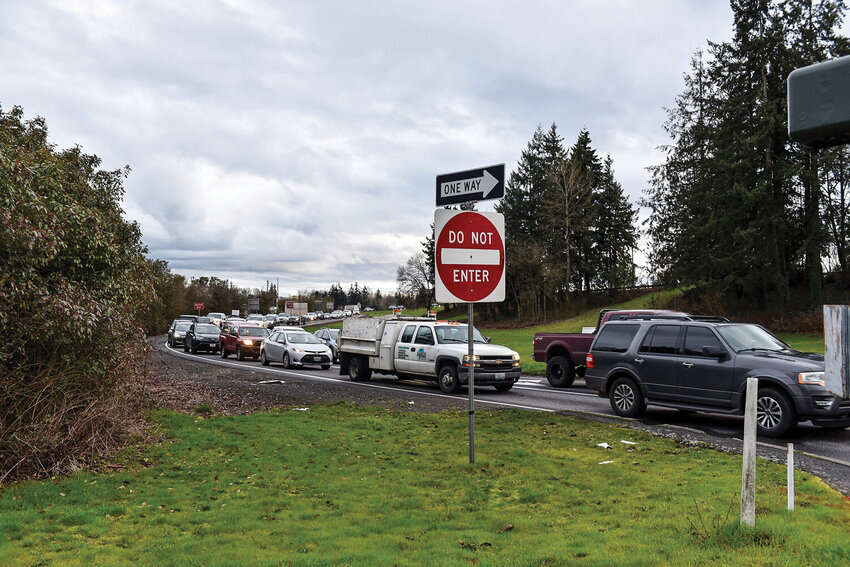 Vehicles wait at a congested intersection near Woodland&rsquo;s Exit 21, where traffic backups are common. The planned improvement project, now delayed until at least 2028, aims to alleviate congestion with redesigned infrastructure.
