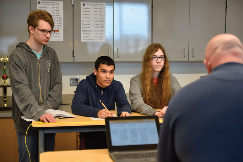 Coach David Jacobson leads a practice session with Nathan Walker, James Haddix, and Katie Thiel as they gear up for the national Quiz Bowl competition in Atlanta.