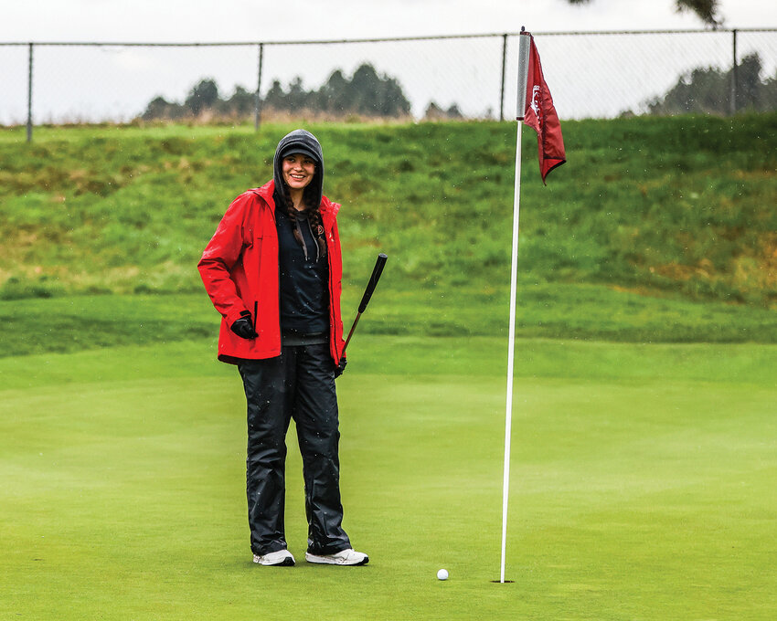 Prairie junior girls golfer Lucia Hill stands proudly next to her near hole-in-one on Tri-Mountain Golf Course's par three hole six in a match against Battle Ground High School on Thursday, March 27.