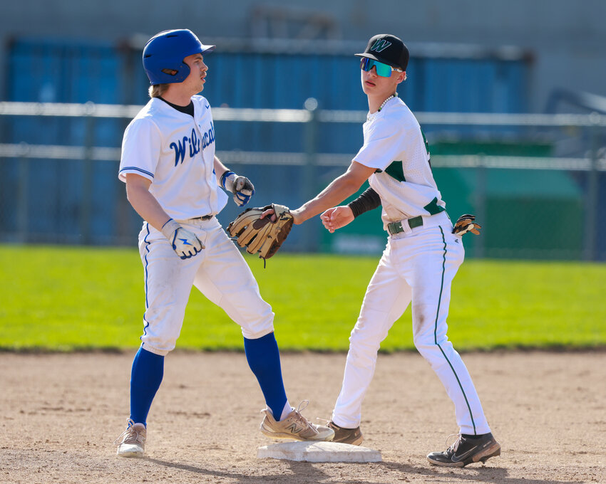 La Center&rsquo;s Justin Fuller stands on second base, left, while Woodland&rsquo;s Jake Sams goes to apply a tag during the La Center Wildcats 12-2 win on Saturday, April 5.