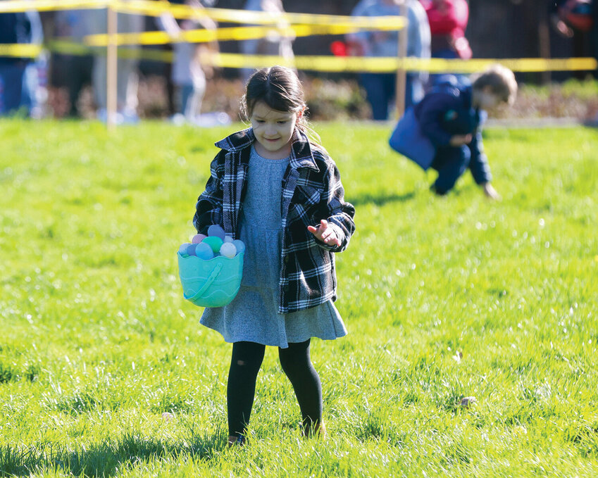 A girl collects Easter eggs during the egg hunt held at Kiwanis Park in Battle Ground in 2024.