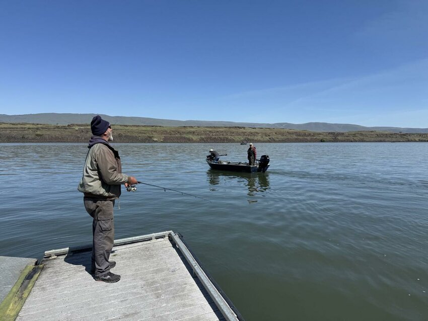 Tommy Ogren hollers over to Wally Cole and his friend John Twyman by The Dalles Marina on Monday. All three men were fishing for Northern Pikeminnows.