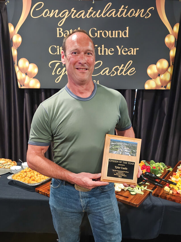 Tyler Castle holds his Citizen of the Year award during the April 15 ceremony at Prairie Tavern.