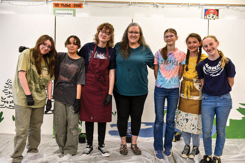 From left to right, Mya Cluphf, Eunice Sparks, Isabela Hodston, La Center Arts Council Director Krissy DuBois, Stella Lindsay, Delilah Higgins and Amelia Benson pose in front of the unfinished mural on Saturday, April 26.