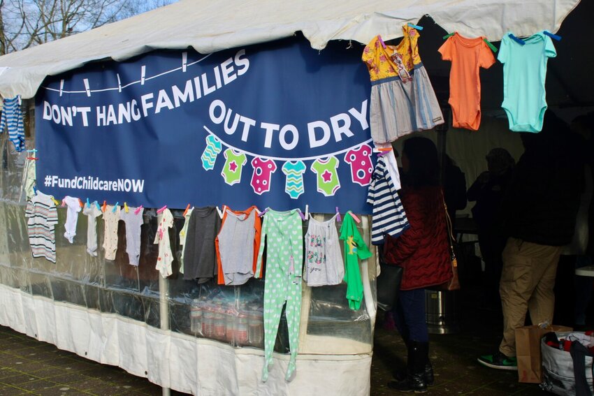 Advocates who urged the Oregon Legislature to increase child care funding in January 2024 hung onesies and other children&rsquo;s clothes on a tent outside the Capitol in Salem. They planned to donate the clothes after Thursday&rsquo;s demonstration. (Photo by Julia Shumway/Oregon Capital Chronicle)