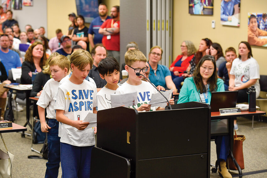 Dozens of elementary and middle school students wait in line to speak at the podium, many wearing "Save Aspire" shirts. They urged the board to preserve the ASPIRE magnet program amid looming budget cuts during a Monday, April 28 meeting.