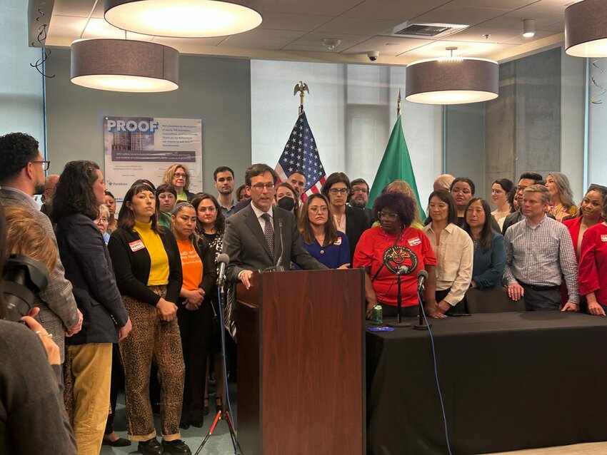 Gov. Bob Ferguson, podium, makes remarks during a bill signing event on May 7, 2025, where he signed a law that will cap rent increases for many residential tenants across Washington at 10% or less annually. (Photo by Jake Goldstein-Street/Washington State Standard)