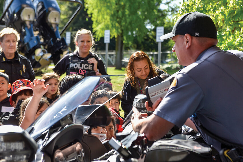 A Washington State Patrol officer shows students a speedometer and WSP motorcycles during a safety demonstration on May 8. The event was part of Safety City, which teaches first graders real-world safety skills through interactive stations.