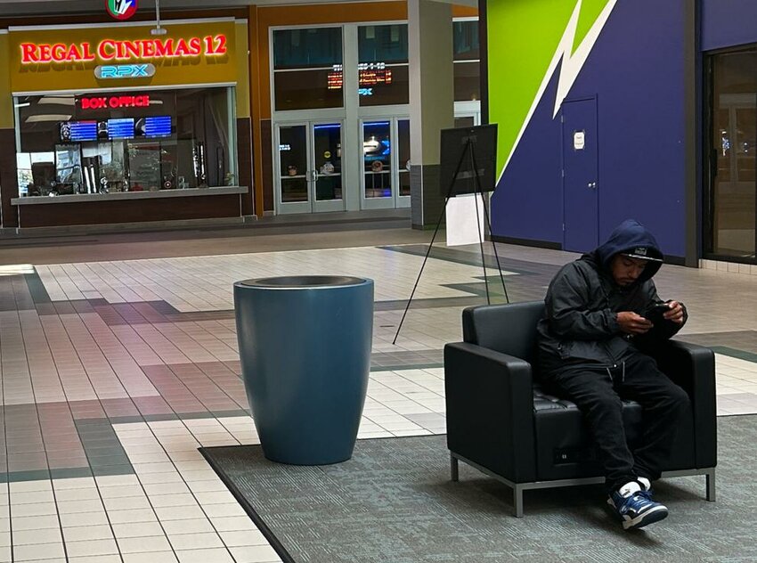 A man sits in a chair outside the Regal Cinema on Thursday, June 5 at the Three Rivers Crossing in Kelso.