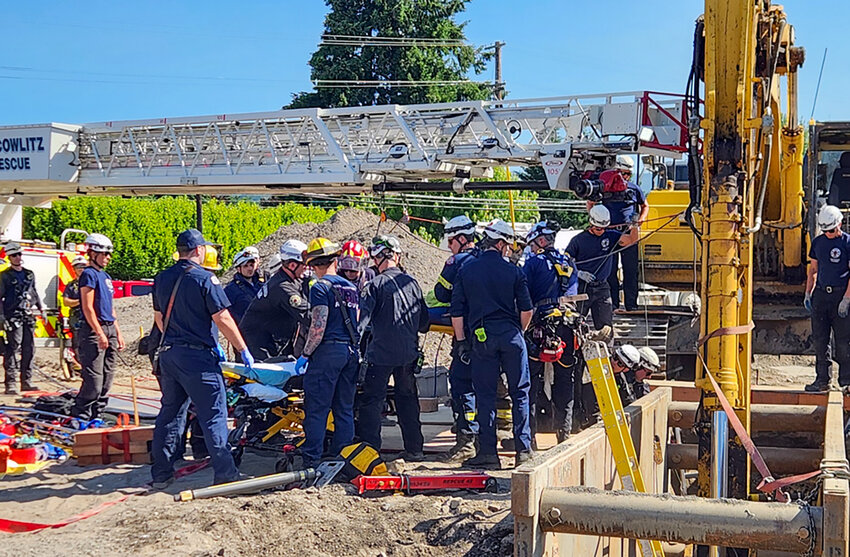 First responders work to rescue an injured worker after heavy machinery fell on him while he was in a work-site trench on Tuesday, June 3, in Woodland.