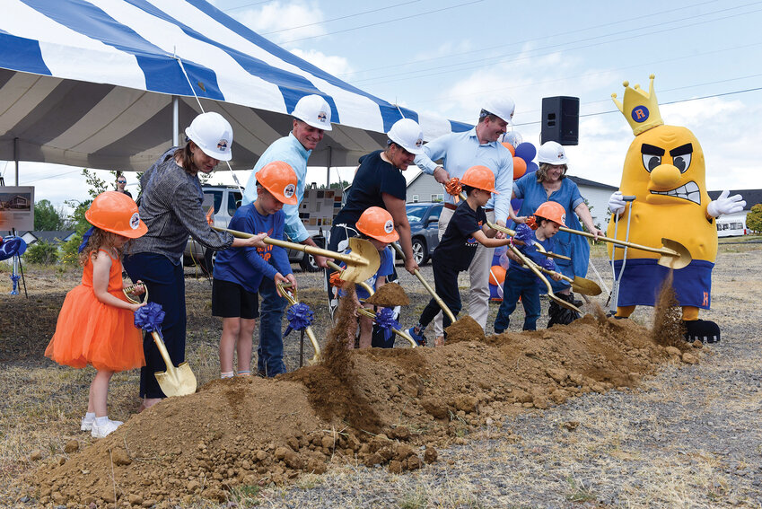 Students join Ridgefield School District board members as they dig into the soil with golden shovels during the June 19 groundbreaking ceremony. The event marks the start of construction on the district's third elementary school, slated to open in August 2026.