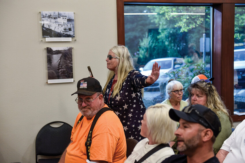Kimberlee Goheen Elbon stands up and demands that residents have a back-and-forth conversation with council members and the mayor during the public hearing at the start of the city council meeting, which stopped proceedings. The June 25 meeting ended in a 3-2 vote to approve the Downtown and Timmen Landing subarea plans.
