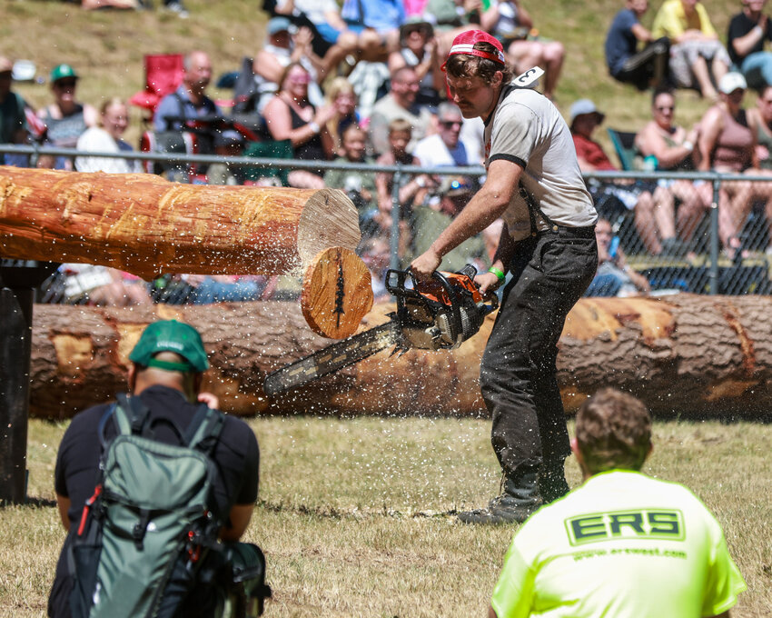 Participants in the Modified Saw event during the Amboy Territorial Days&rsquo; Log Show on Saturday, July 12, cut a slice off two logs and run across a log in between cuts in a competition for the fastest time between the two contestants.